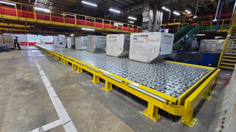 Singapore Airlines cargo containers on a yellow ball transfer deck in a cargo terminal.